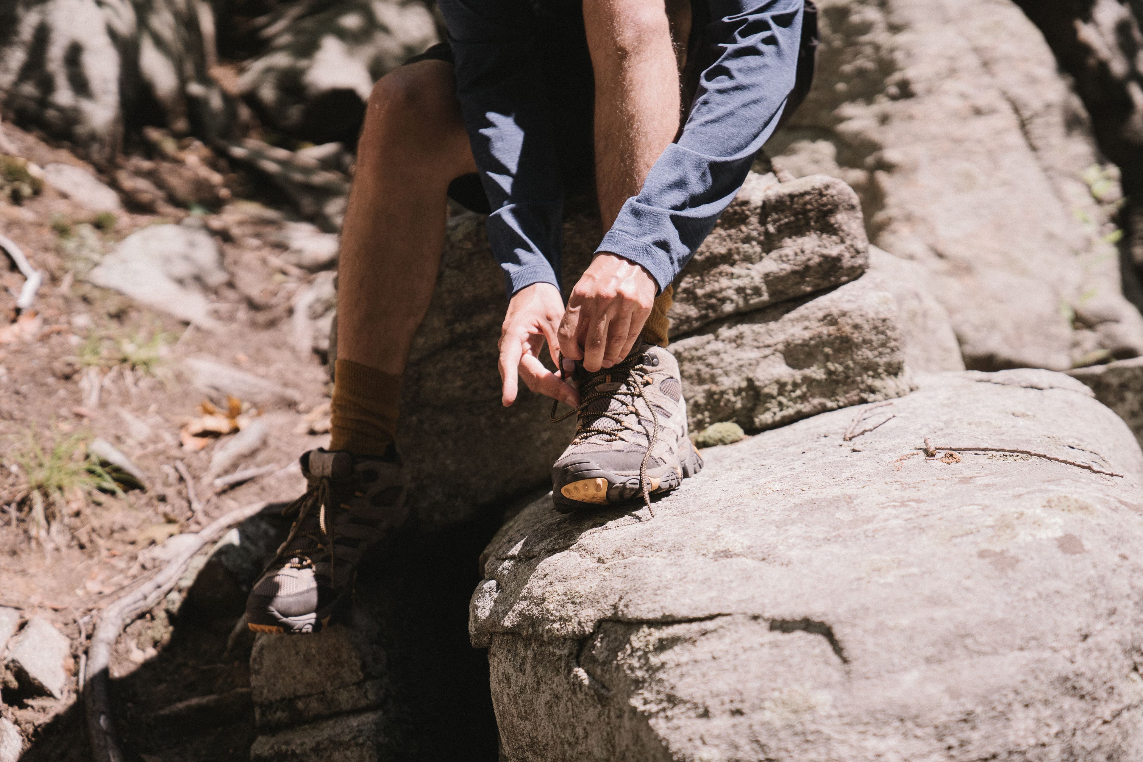 Randonneur ajustant ses chaussettes et chaussures avant le départ